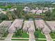 Aerial view of single-story homes with tile roofs, manicured lawns, and lush landscaping at 501 Sotheby Way, Debary, FL 32713