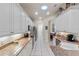 Galley kitchen featuring white cabinets, granite counters, and stainless steel appliances at 501 Sotheby Way, Debary, FL 32713