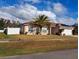 Charming single-story home with a well-maintained lawn, palm tree and white fence at 550 Oak Branch Cir, Kissimmee, FL 34758