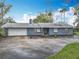 Single-story home with a nautical-themed front yard and attached garage, blending charm and convenience at 607 Powers Ave, Port Orange, FL 32127