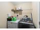 Well-lit laundry room with modern washer and dryer, plus convenient shelving for storage at 618 Minnesota Ave, St Cloud, FL 34769