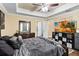 Spacious main bedroom featuring tray ceiling, ceiling fan, and wood-look flooring at 618 Minnesota Ave, St Cloud, FL 34769