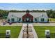 Clubhouse exterior featuring modern farmhouse architecture, a well-manicured lawn, and ample parking at 7071 Painted Bunting Way, St Cloud, FL 34773