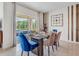 Elegant dining room with modern furniture, a glass top table, unique light fixture, and sliding glass doors to the lanai at 7071 Painted Bunting Way, St Cloud, FL 34773