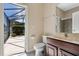 Bathroom boasts a toilet and vanity, seamlessly connected to a screened patio for an indoor-outdoor living experience at 713 Duff Dr, Winter Garden, FL 34787