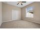 Cozy bedroom with neutral walls, ceiling fan, plush carpet, and a window with blinds, offering a serene retreat at 713 Duff Dr, Winter Garden, FL 34787