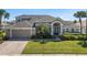 Charming two-story home featuring a well-manicured lawn, brick driveway, and mature landscaping at 713 Duff Dr, Winter Garden, FL 34787