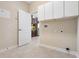 Laundry room with tile floor, white cabinets and access to kitchen at 713 Duff Dr, Winter Garden, FL 34787