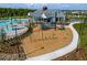 Aerial shot of a playground with swings, slides, and climbing structures, surrounded by lush landscaping at 7182 Painted Bunting Way, St Cloud, FL 34773