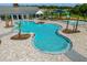 Aerial view of a resort-style pool area with a splash pad surrounded by palm trees and well-manicured landscaping at 7182 Painted Bunting Way, St Cloud, FL 34773