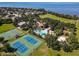 Aerial view showcasing the tennis courts, basketball courts, pool and clubhouse, with a lake backdrop in a planned community at 723 Marotta Loop, Ocoee, FL 34761