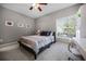 Bedroom with a neutral color scheme, a ceiling fan, and a window view of the trees at 723 Marotta Loop, Ocoee, FL 34761