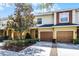 Townhome exterior featuring a well-maintained lawn, landscaping, and two-car garage at 723 Marotta Loop, Ocoee, FL 34761