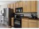 Well-equipped kitchen featuring stainless steel refrigerator and black appliances at 723 Marotta Loop, Ocoee, FL 34761