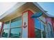 Corner exterior of a red home with white trim, decorative anchor, and sign that reads 'Unit 106' at 833 E 24Th Ave # 106, New Smyrna Beach, FL 32169