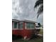 Red stucco home with white trim featuring a decorative anchor and a cloudy sky background at 833 E 24Th Ave # 106, New Smyrna Beach, FL 32169