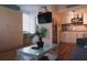 Modern living room featuring wood floors, a flat screen TV, and view of the stainless steel kitchen appliances at 833 E 24Th Ave # 106, New Smyrna Beach, FL 32169