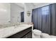 Clean bathroom featuring a dark vanity with a granite countertop and shower with a curtain at 8718 Shimmering Pine Pl, Sanford, FL 32771