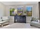 Bedroom detail featuring a dresser with decor, comfortable armchairs, and natural light streaming through the windows at 8718 Shimmering Pine Pl, Sanford, FL 32771