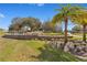 Beautiful entrance to the community with stone landscaping, a water feature and palm trees at 8718 Shimmering Pine Pl, Sanford, FL 32771