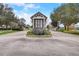 Elegant entrance gate featuring stone accents, lush landscaping and a white picket fence at 8718 Shimmering Pine Pl, Sanford, FL 32771