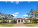 Beautiful one-story home boasts lush landscaping, complemented by a brick driveway under a clear blue sky at 8718 Shimmering Pine Pl, Sanford, FL 32771