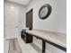 Clean mudroom with built-in bench, countertop, coat hooks, decorative clock, and neutral tile floors at 8718 Shimmering Pine Pl, Sanford, FL 32771