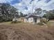 Overgrown front yard of a distressed single-story home in need of renovations at 8801 Hackney Prairie Rd, Orlando, FL 32818