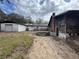 The home's exterior shows signs of age, a multi-door garage, and an unkempt lawn at 8801 Hackney Prairie Rd, Orlando, FL 32818