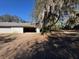 Open multi-door garage awaiting renovation, set amongst mature trees and lot at 8801 Hackney Prairie Rd, Orlando, FL 32818