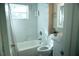 Bright bathroom featuring tiled shower-tub combination, white vanity, and ample natural light from a window at 919 N Hastings St, Orlando, FL 32808