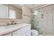 Bright bathroom featuring a marble-tiled shower with glass door, single sink and white vanity at 926 Ensenada Dr, Orlando, FL 32825