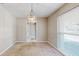 Cozy dining area with neutral walls, plush carpet, a chandelier and a window overlooking the yard at 926 Ensenada Dr, Orlando, FL 32825