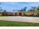 Ranch-style home with a long driveway, mature landscaping, and a covered entryway at 926 Ensenada Dr, Orlando, FL 32825