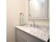 Bathroom vanity with marble countertop, modern faucet, and a gray framed mirror at 938 S Bumby Ave, Orlando, FL 32806