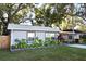 Home featuring a gray exterior, trimmed windows and a green lawn at 938 S Bumby Ave, Orlando, FL 32806