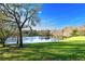 Beautiful lake view with trees reflecting in the water with a lush green lawn at 938 S Bumby Ave, Orlando, FL 32806