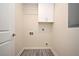 Neat laundry room featuring gray flooring, white walls, and overhead storage at 938 S Bumby Ave, Orlando, FL 32806