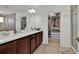 Bathroom featuring dual sinks, wood cabinets, walk-in closet and a large mirror at 17019 Seville Orange Rd, Winter Garden, FL 34787