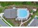 Overhead shot of a refreshing community pool surrounded by patio furniture, greenery, and a nearby building at 17019 Seville Orange Rd, Winter Garden, FL 34787