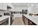 Bright, spacious kitchen with white cabinets, stainless steel appliances, and quartz countertops at 17019 Seville Orange Rd, Winter Garden, FL 34787