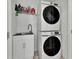 Laundry area features a stacked washer and dryer and a utility sink with patterned flooring and a wire shelf at 17019 Seville Orange Rd, Winter Garden, FL 34787