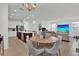 Open-concept living room and dining area with pendant lighting and stainless steel appliances at 17019 Seville Orange Rd, Winter Garden, FL 34787