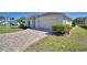 A home exterior featuring a large two car garage, well-manicured landscaping, and a brick paved driveway at 1010 High Vista Dr, Davenport, FL 33837