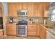 Well-lit kitchen with stainless steel appliances, granite counters, and tile backsplash at 1010 High Vista Dr, Davenport, FL 33837