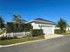 Detached two-car garage featuring a white door, exterior lighting, and well-manicured landscaping at 1024 Prosperity Dr, Winter Garden, FL 34787