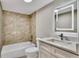 Bathroom featuring illuminated mirror, modern vanity, decorative tile accents, and a tub with shower at 110 Scottsdale Sq # 110, Winter Park, FL 32792