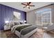 Bedroom featuring a striking accent wall, ceiling fan, and an abundance of natural light at 13046 Island Breeze Ct, Orlando, FL 32824