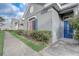 Attractive gray home featuring a blue front door, coordinated shutters and trimmed hedges at 13046 Island Breeze Ct, Orlando, FL 32824