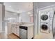 Bright kitchen with stainless steel appliances, white cabinetry, and adjacent laundry closet at 13046 Island Breeze Ct, Orlando, FL 32824